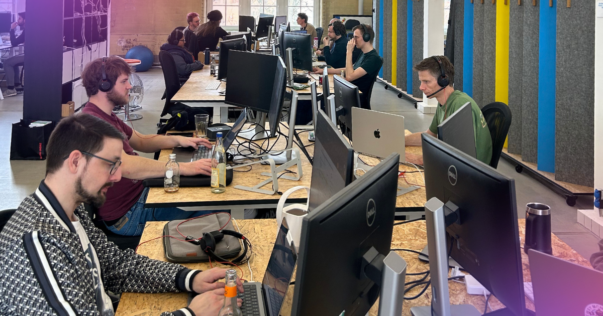 Several people sitting at desks and working on computers.